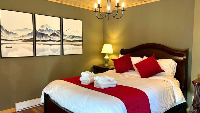 Ein Schlafzimmer mit einem Bett und drei Gemälden an der Wand