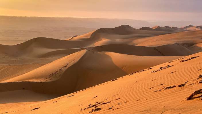Eine Wüste mit vielen Sanddünen an einem bewölkten Tag