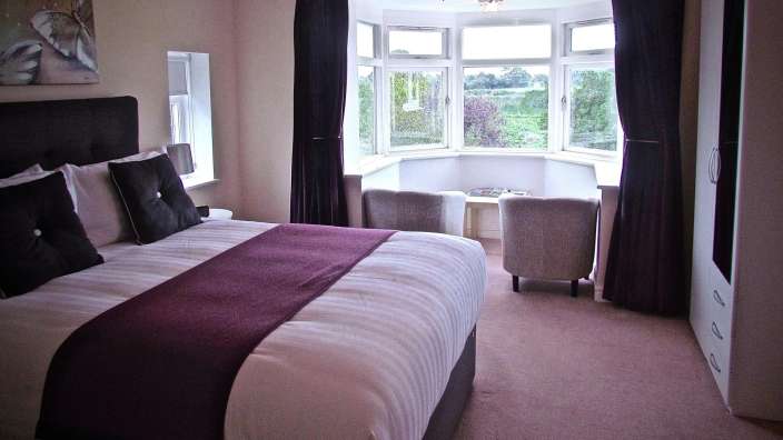 Ein Schlafzimmer mit einem Bett und zwei Stühlen