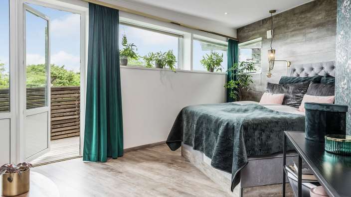 Ein Schlafzimmer mit einem Bett und grünen Vorhängen