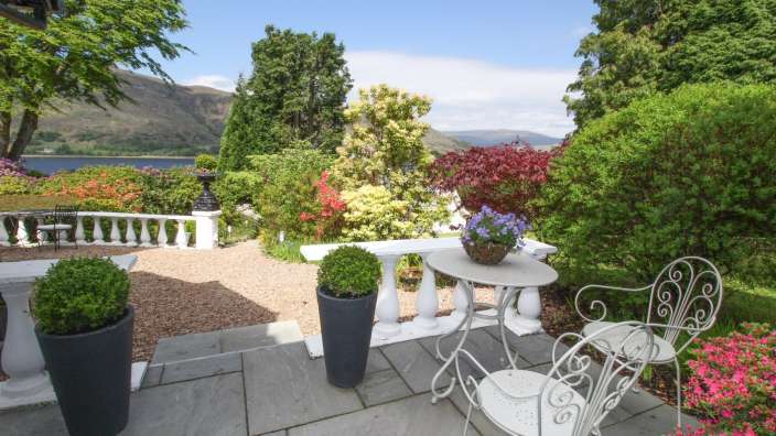 Ein Tisch und Stühle auf einer Terrasse mit Blick auf einen See