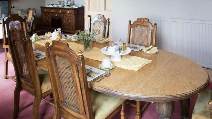 Ein Esszimmer mit einem Holztisch und Stühlen