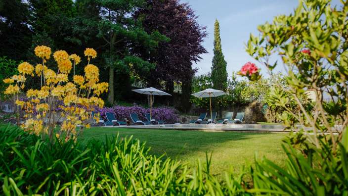 Ein Pool mit Stühlen und Sonnenschirmen im Hintergrund