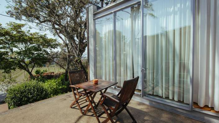 Ein Tisch und Stühle stehen vor einem großen Fenster