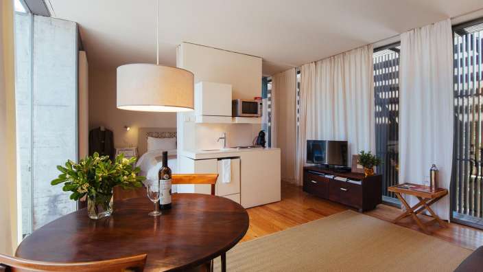 Ein Wohnzimmer mit einem Tisch und Stühlen und einer Flasche Wein