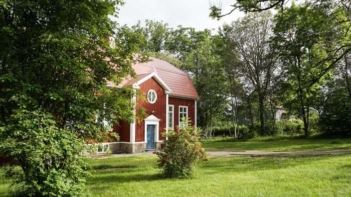 Ein rotes und weißes Haus mit einer blauen Tür