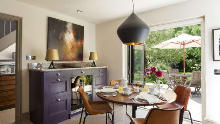 Ein Esszimmer mit einem Tisch und Stühlen und einem Gemälde an der Wand