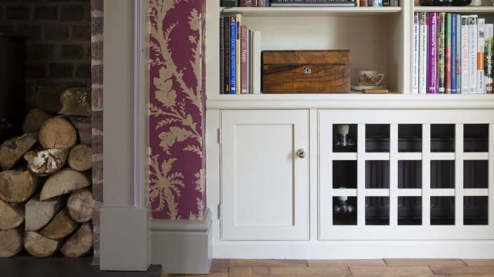 Eine Reihe von Büchern steht auf einem Regal neben einem Kamin