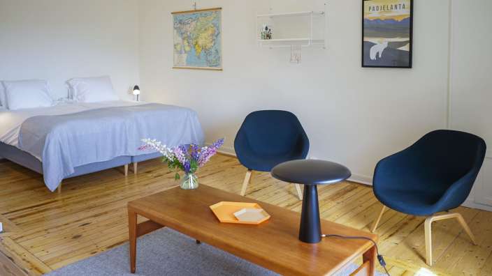 Ein Schlafzimmer mit einem Bett und zwei Stühlen und einem Plakat mit der Aufschrift padjelanta