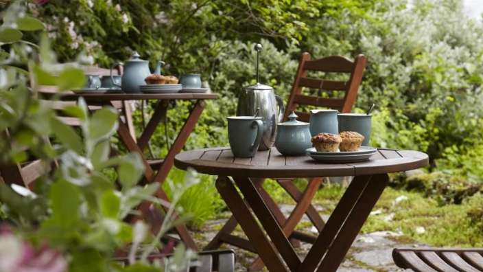 Ein Tisch mit einer Kaffeekanne und zwei Muffins darauf