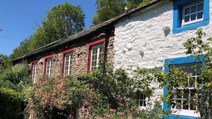 Eine Reihe von Häusern mit roten und weißen Fenstern