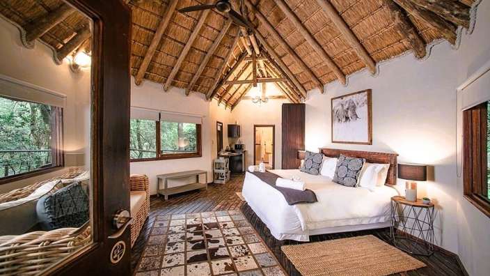 Ein Schlafzimmer mit Strohdach und einem Bett