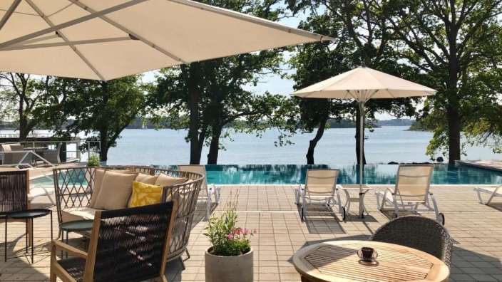 Ein Tisch und Stühle auf einer Terrasse mit Blick auf einen Pool