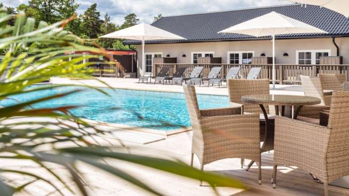 Ein Tisch und Stühle stehen neben einem Swimmingpool