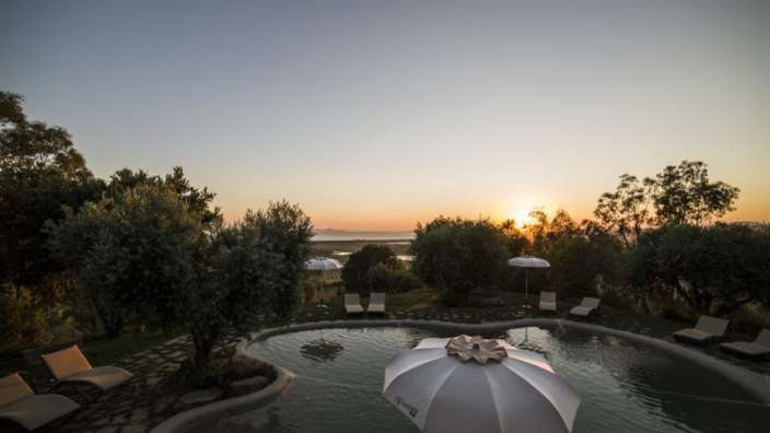 Ein weißer Regenschirm steht in der Mitte eines Pools
