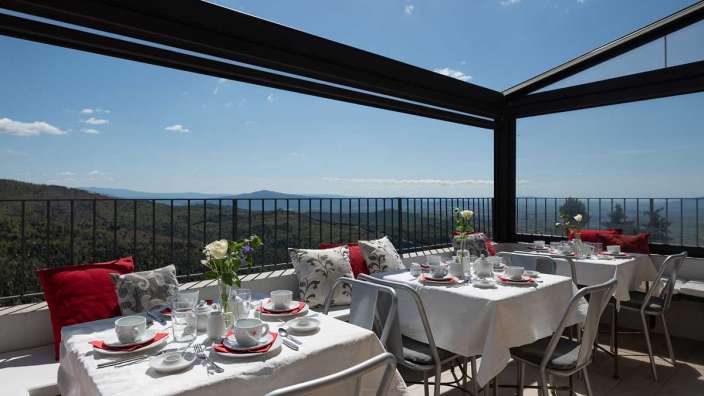 Ein Tisch und Stühle auf einer Terrasse mit Blick auf die Berge
