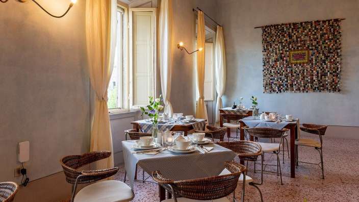 Ein Esszimmer mit Tischen und Stühlen und einem Gemälde an der Wand