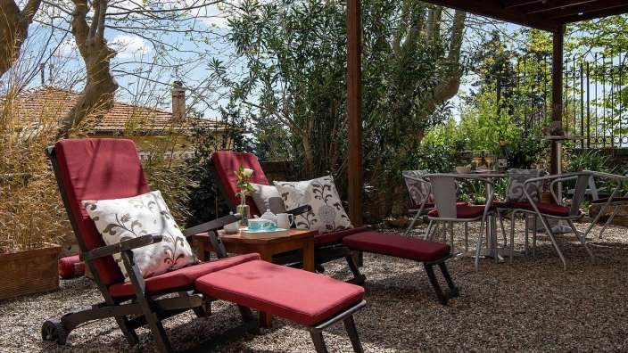 Eine Terrasse mit roten Stühlen und einem Tisch