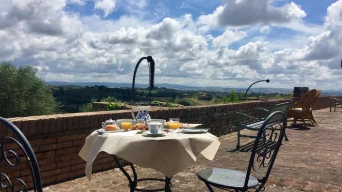 Ein Tisch mit Essen und Getränken auf einer Terrasse mit Blick auf die Landschaft