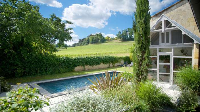 Ein Haus mit einem Pool und einem Weinberg im Hintergrund