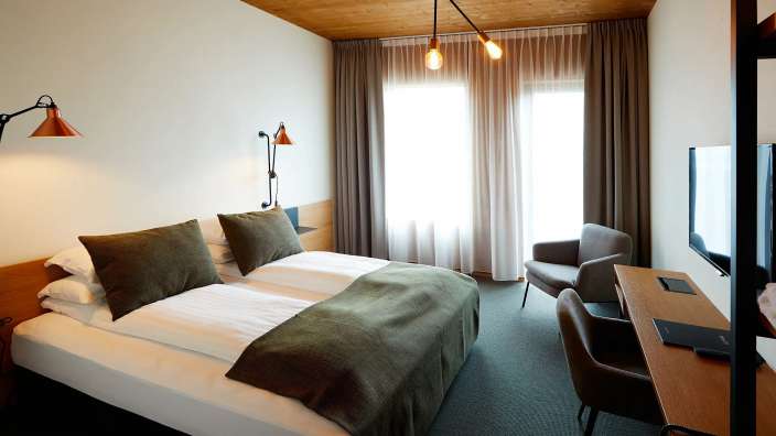 Ein Hotelzimmer mit zwei Betten und einem Stuhl