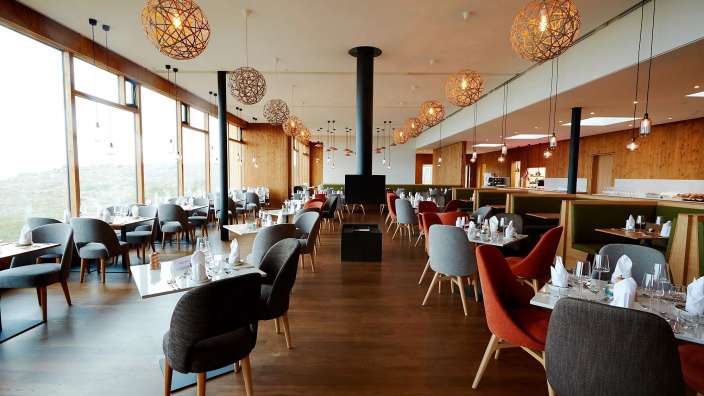 Ein Restaurant mit vielen Tischen und Stühlen und einem Kamin