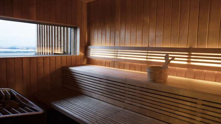 Eine Holzsauna mit einem Eimer und einem Fenster