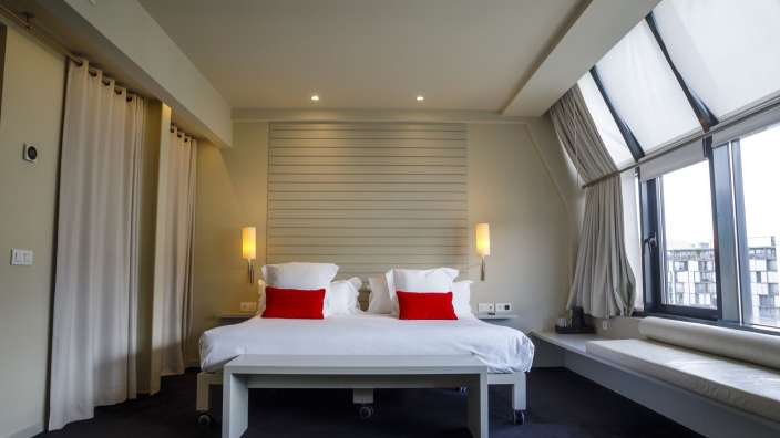 Ein Hotelzimmer mit weißem Bett und roten Kissen