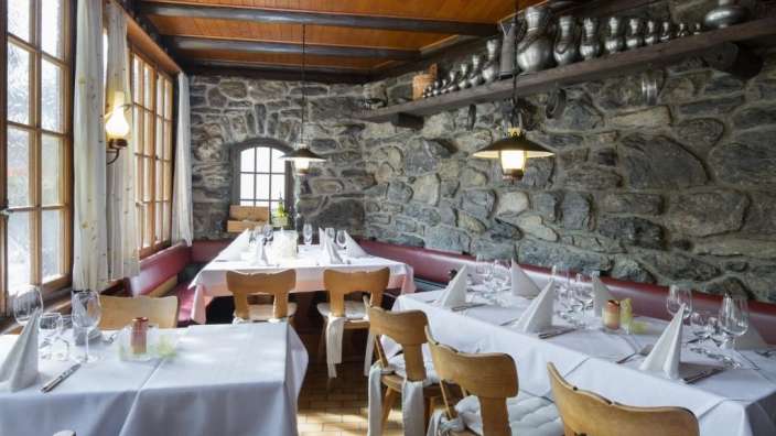 Tische und Stühle in einem Restaurant mit Steinwänden