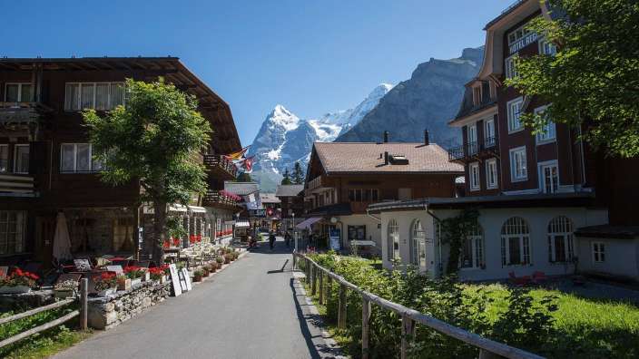 Eine Straße in einem kleinen Dorf mit einem Berg im Hintergrund