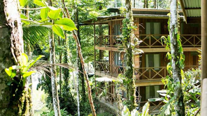 Eine Reihe von Holzhäusern mit Balkonen im Dschungel