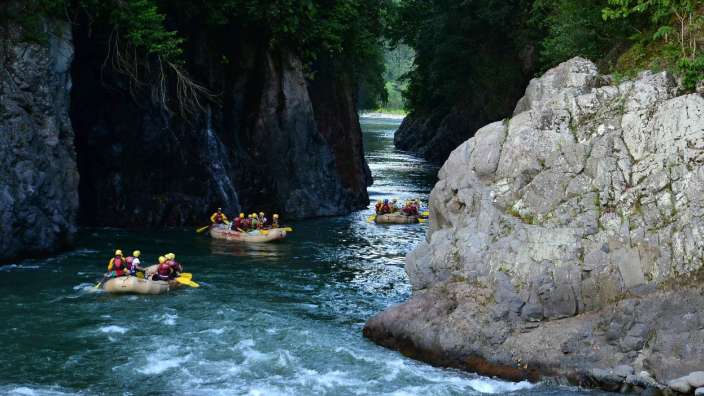 Eine Gruppe von Menschen fährt in einem Fluss mit Rädern