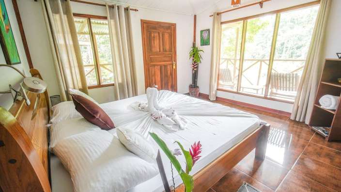 Ein Schlafzimmer mit einem Bett und vielen Fenstern