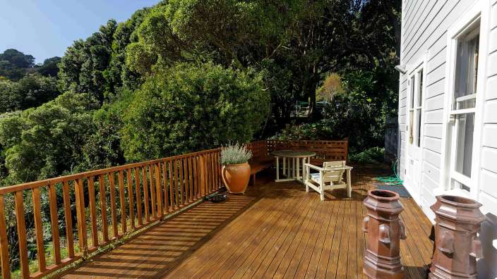 Ein Holzdeck mit einem Tisch und Stühlen darauf