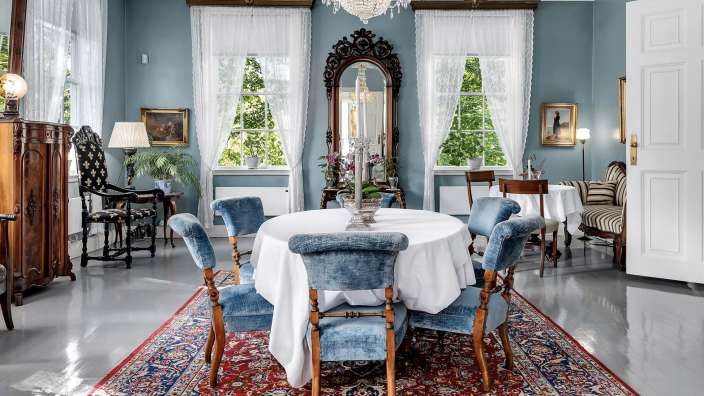 Ein Esszimmer mit einem Tisch und Stühlen und einem Teppich