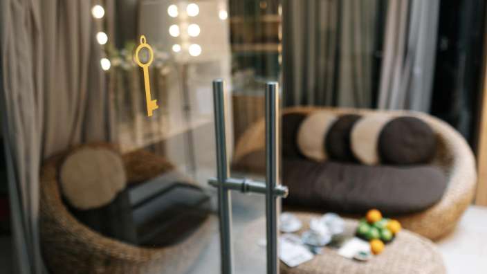 Ein gelber Schlüssel hängt an einer Glastür