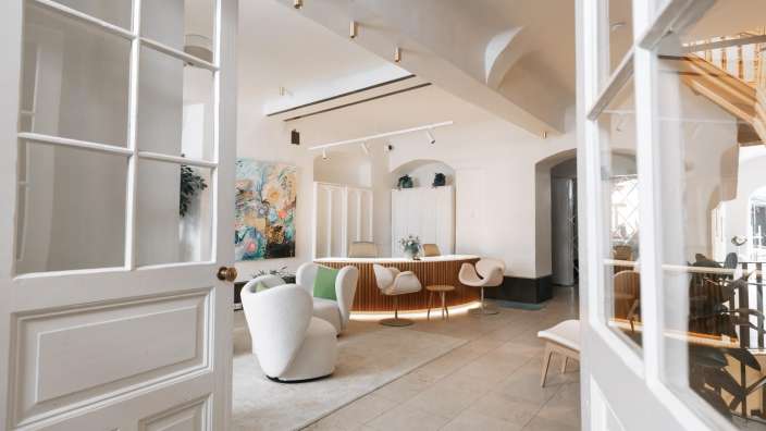 Eine weiße Tür führt in einen Raum mit einem Tisch und Stühlen