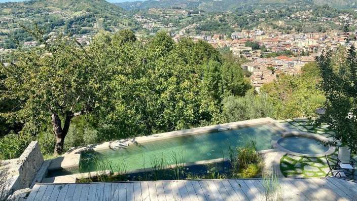 Ein Pool mit Blick auf eine Stadt mit Bergen im Hintergrund