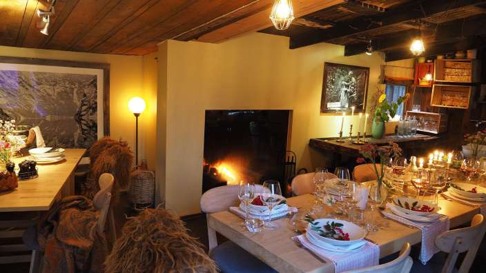 Ein Wohnzimmer mit einem Tisch und Stühlen und einem Kamin