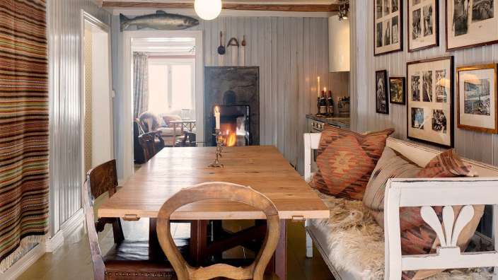 Ein Esszimmer mit einem Tisch und Stühlen und Bildern an der Wand