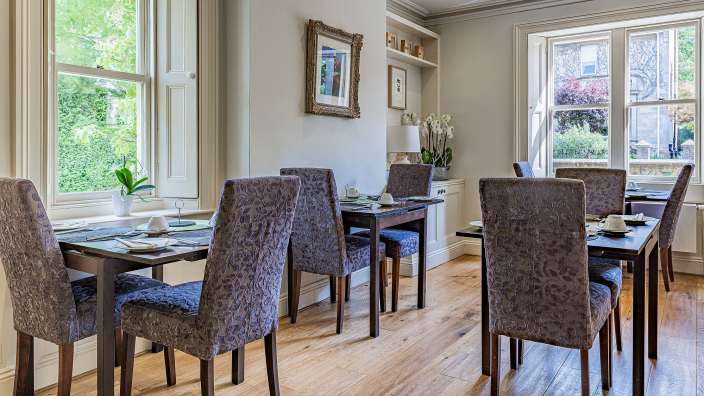 Ein Esszimmer mit vielen Tischen und Stühlen