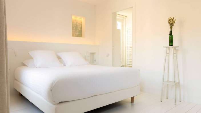 Ein Schlafzimmer mit einem Bett und einer Flasche auf einem Ständer