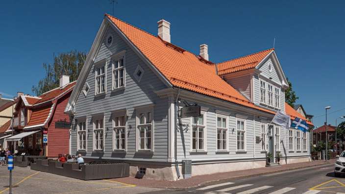 Ein großes weißes Holzhaus mit einem orangefarbenen Dach