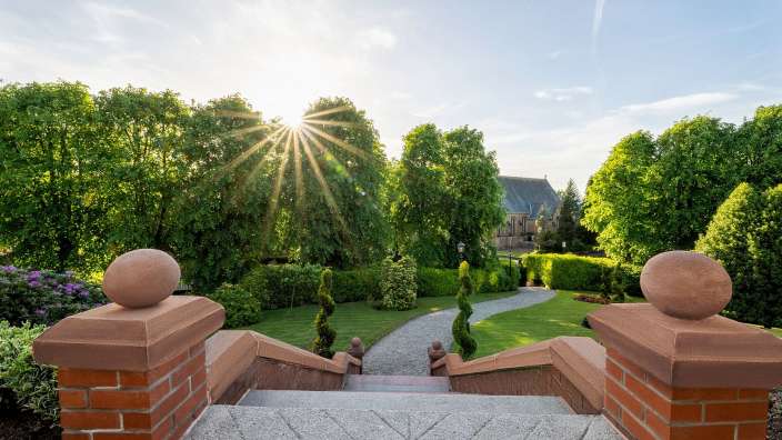 Die Sonne scheint durch die Bäume in einem Park