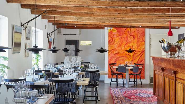 Ein Speisesaal mit Holzbalken und einem Gemälde an der Wand