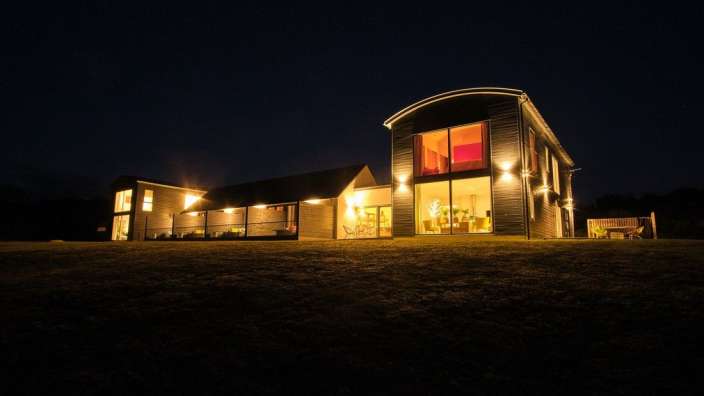 Ein Haus mit vielen Fenstern nachts beleuchtet