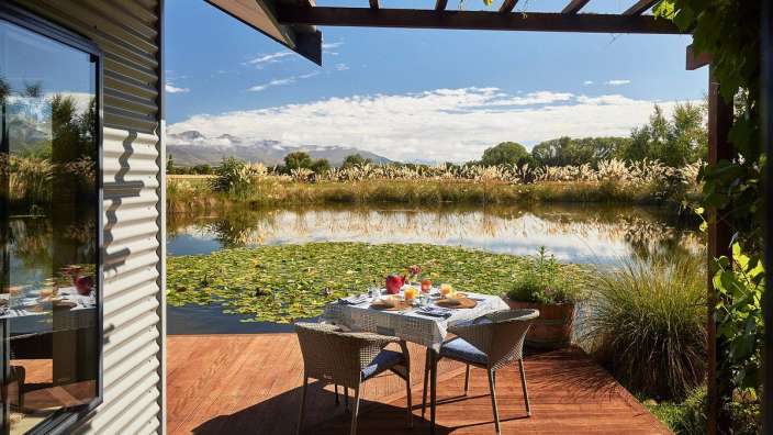 Ein Tisch und Stühle auf einem Deck mit Blick auf einen Teich