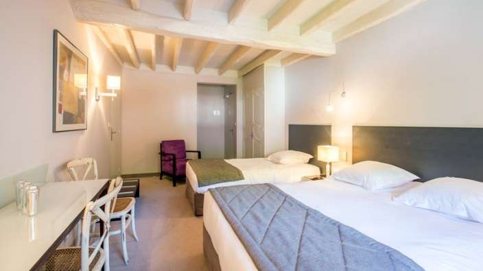 Ein Hotelzimmer mit zwei Betten und einem Schreibtisch