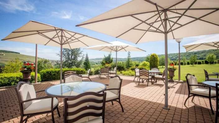 Eine Terrasse mit Tischen und Stühlen und vielen Sonnenschirmen