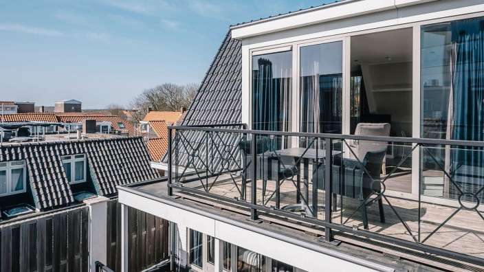 Ein Balkon mit einem Tisch und Stühlen darauf